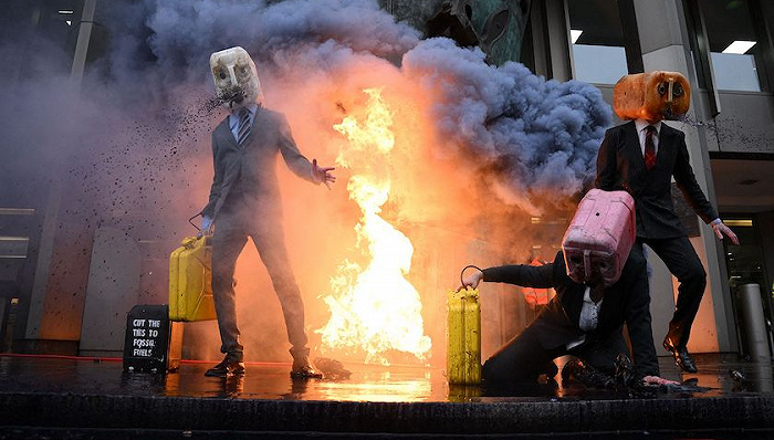 英国海洋反抗运动示威者在国际海事组织办公室外点燃模拟石油，抗议使用化石燃料